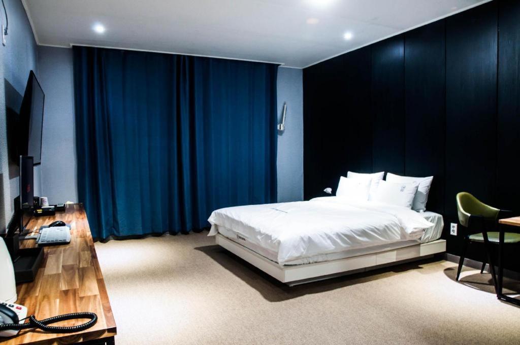 Heitz Hotel的卧室配有白色的床和蓝色窗帘