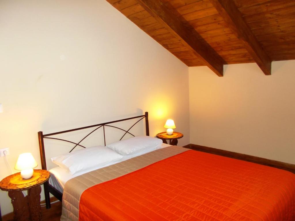 雅莎尼奥Porto Katsiki Blu的一间卧室配有一张红色的床和两盏灯