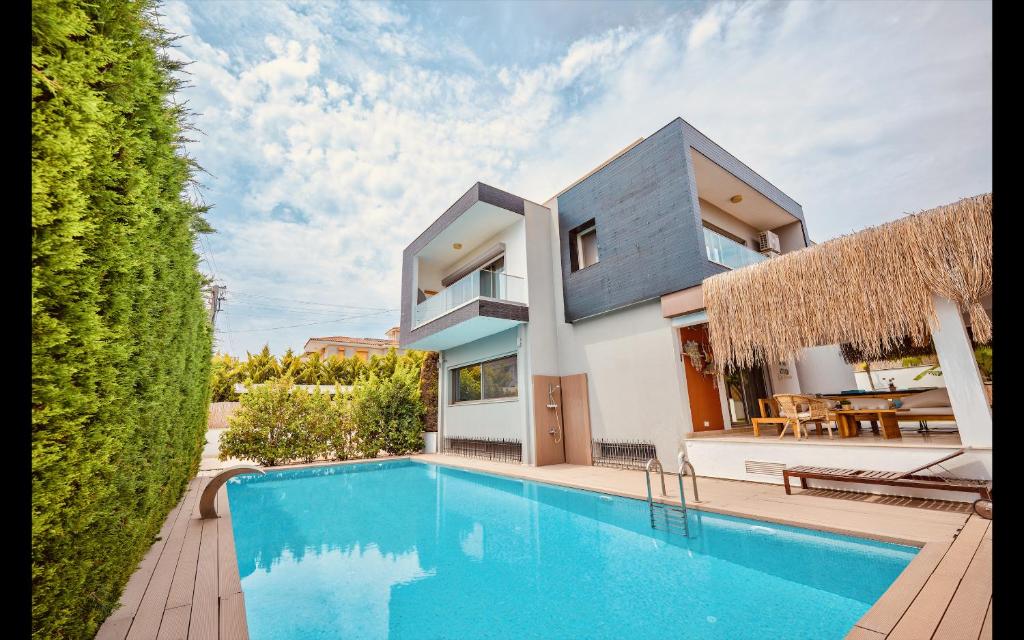 切什梅Luxury Seadside Vacation Villa with Privacy (extra comfort for large groups)的房屋前有游泳池的房子
