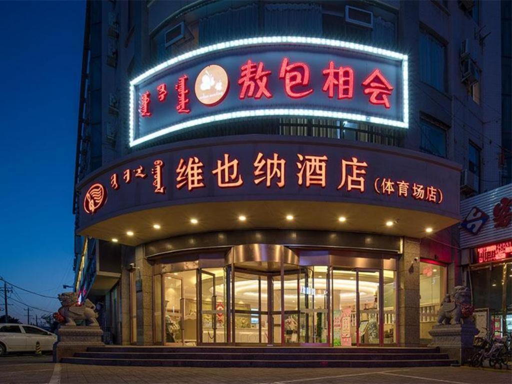 呼和浩特Vienna Hotel Inner Mongolia Hohhot Railway Station Gongzhufu Metro Station的前方有 ⁇ 虹灯标志的建筑