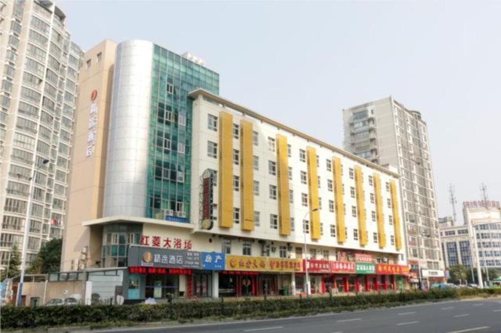 常州JTOUR Inn Changzhou Wanda Plaza Railway Station的一座大建筑,上面有黄色和红色的标志