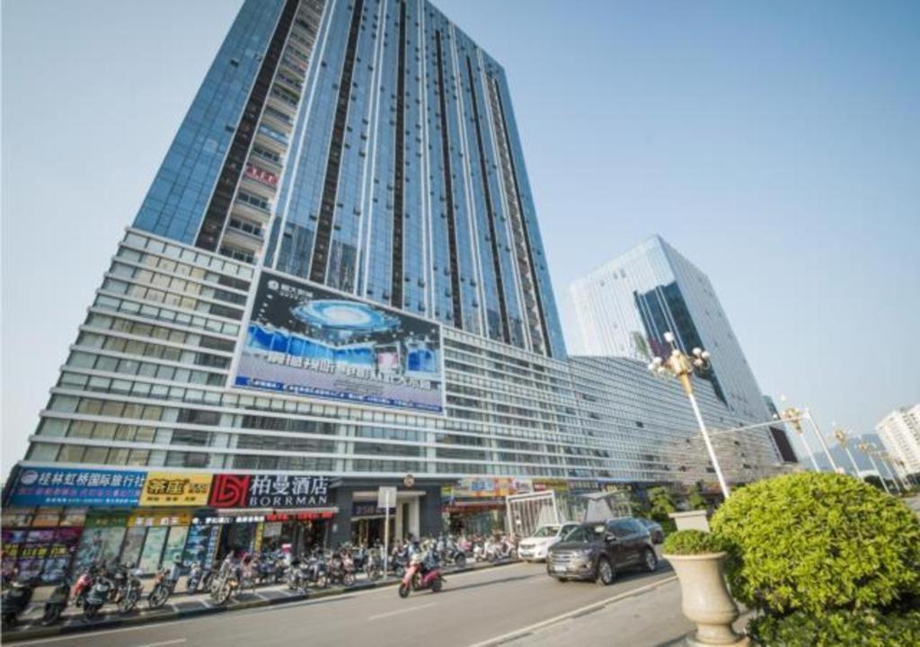 桂林Borrman Hotel Guilin High-speed Railway North Station Evergrande Plaza的一座大型建筑前面有很多人