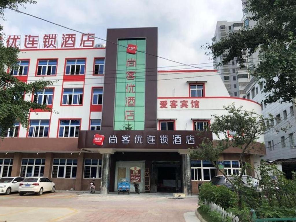 山后街Thank Inn Hotel Anhui Chuzhou Fengyang County Bus Station的前面有标志的建筑