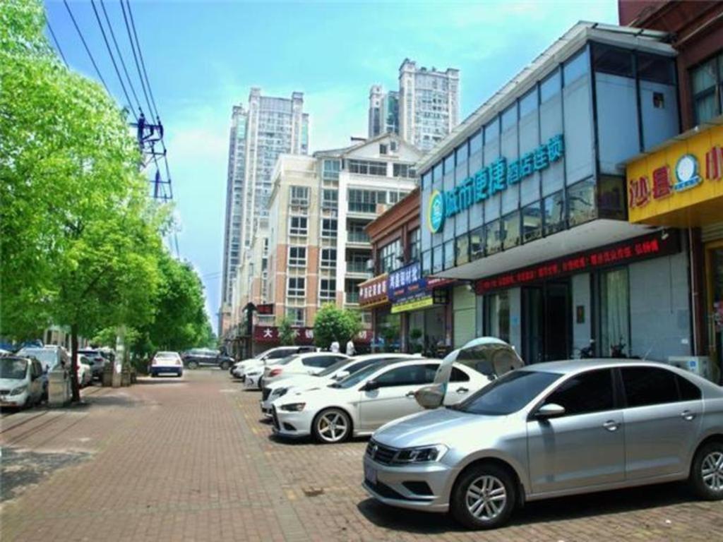 黄石City Comfort Inn Huangshi Wanda Plaza Huashan Road的城市街道上一排停车的汽车