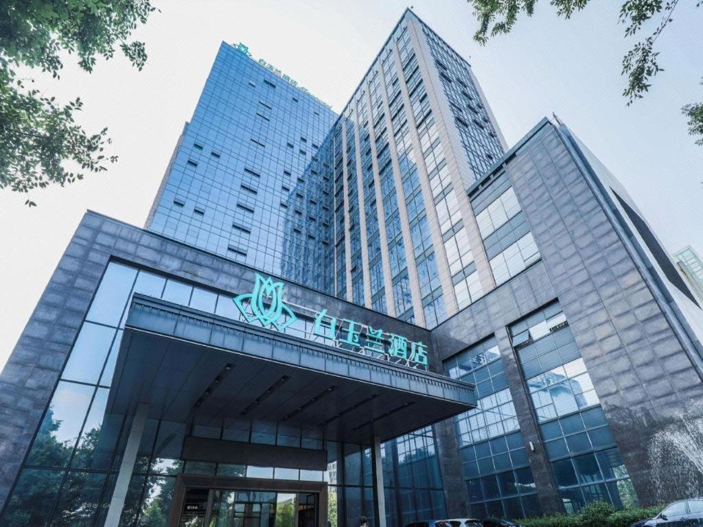 桐乡Magnotel Tongxiang Shimao Center的一座大型玻璃建筑,上面有标志