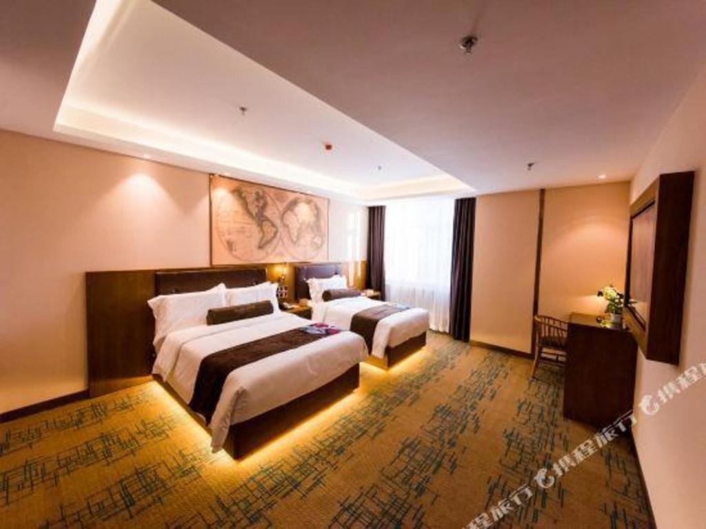 长春James Joyce Coffetel Changchun People's Square的酒店客房设有两张床和窗户。