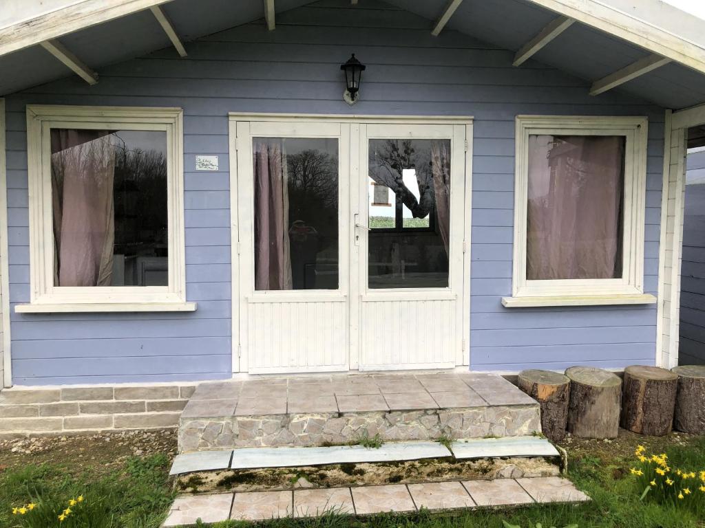 Les Chalets de Babeth et Cathy的蓝色的房子,有白色的门和窗户
