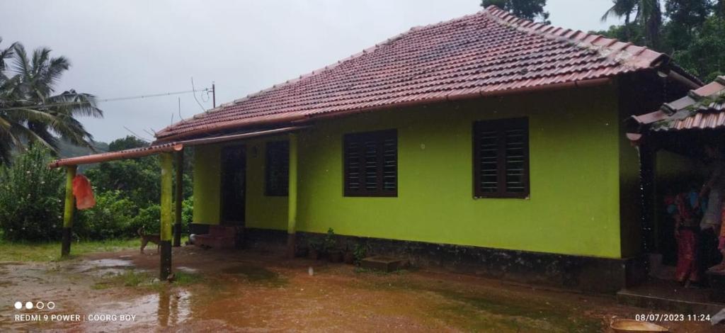 PadakaluHarakoppa Hills的一座带红色屋顶的绿色小房子