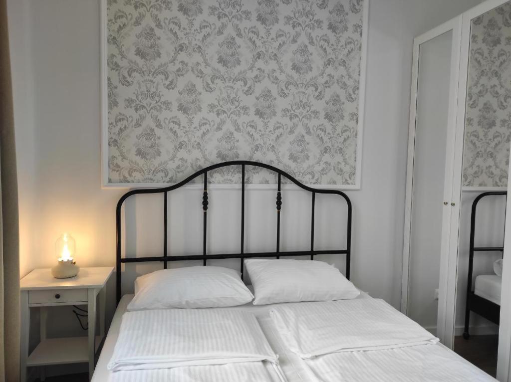 塔尔努夫Lawendowy - Apartamenty Smart Projekt的一间卧室配有一张床,墙上贴有壁纸