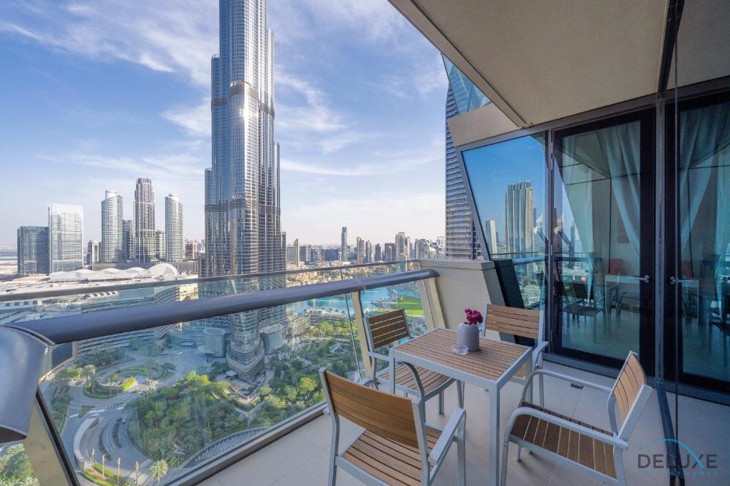 迪拜Gorgeous 2BR Apartment in Burj Vista Tower 1 Downtown Dubai by Deluxe Holiday Homes的阳台配有桌椅,享有城市美景。