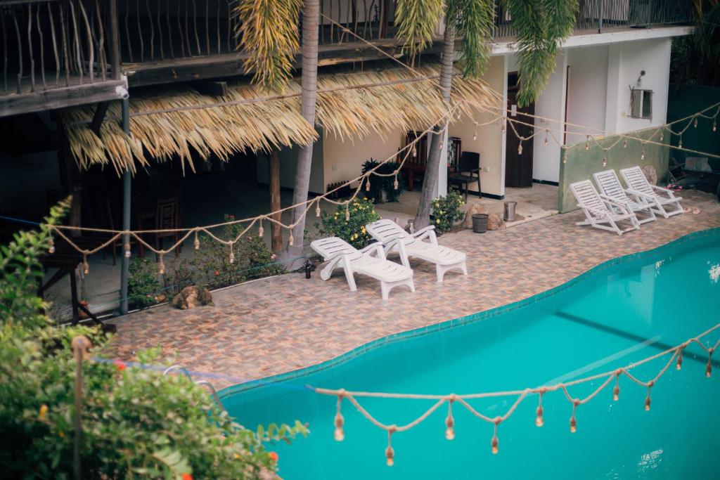 阿鲁甘湾Shell Resort的一组白色椅子和一个游泳池