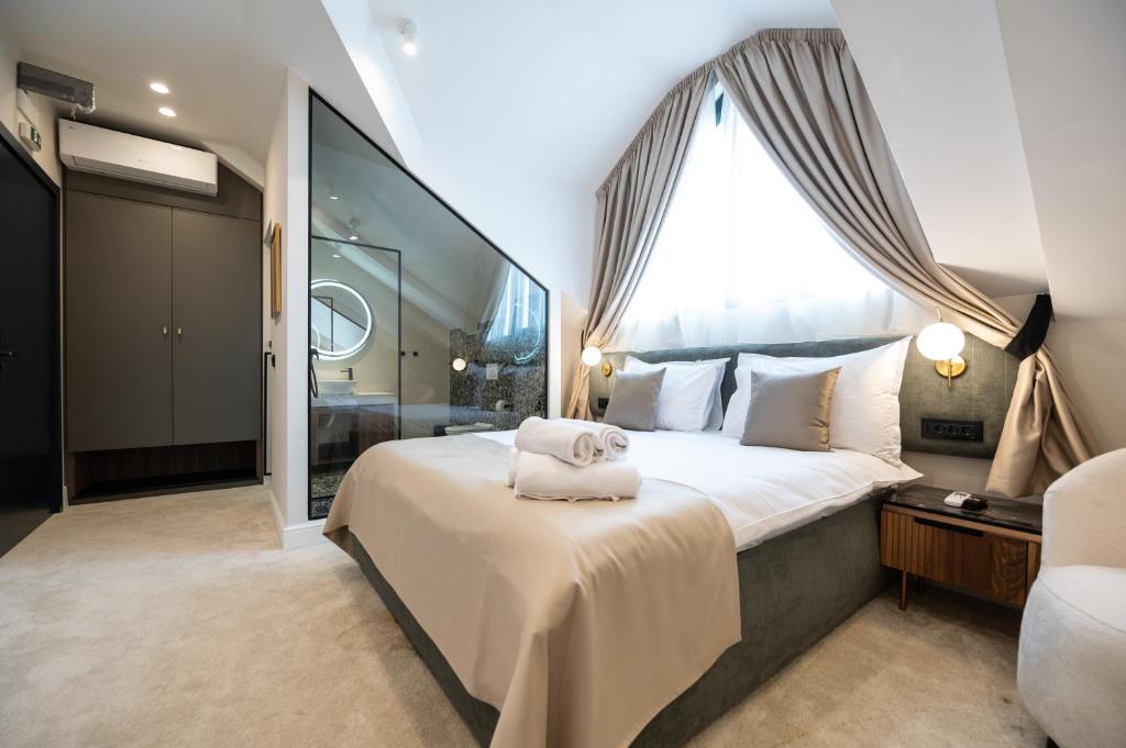 贝尔格莱德Boem Exclusive Rooms Skadarlija的一间卧室设有一张大床和一个大窗户