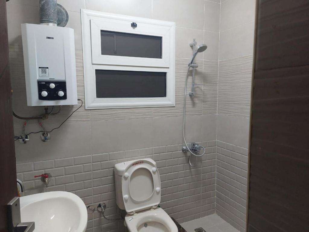 Sīdī Sālimمصر الجديدة的一间带卫生间、水槽和窗户的浴室