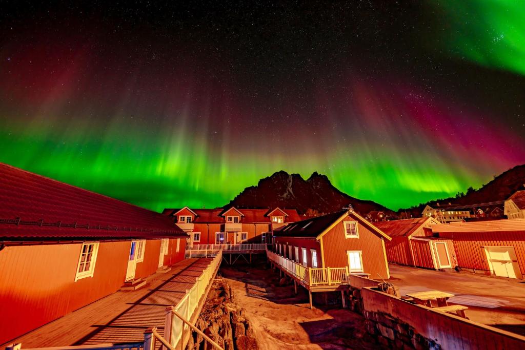 SennesvikUre Lodge的一座拥有建筑和房屋的城镇的极光