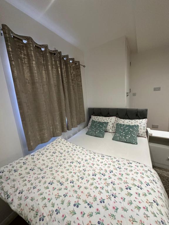 LewishamSmart Cosy/Small Double Room in Oakridge Road Bromley的一间卧室配有一张带花卉床罩和枕头的床