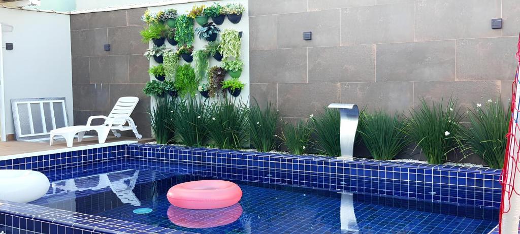 大普拉亚Pousada Vila Real PG的浴室内带粉红色凳子的游泳池