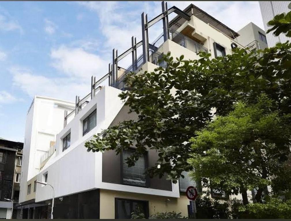 台北在家行旅 西門館的一座白色的建筑,上面设有一个阳台