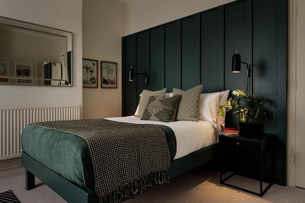 林肯Brayford House的一间卧室配有一张大床和绿色床头板