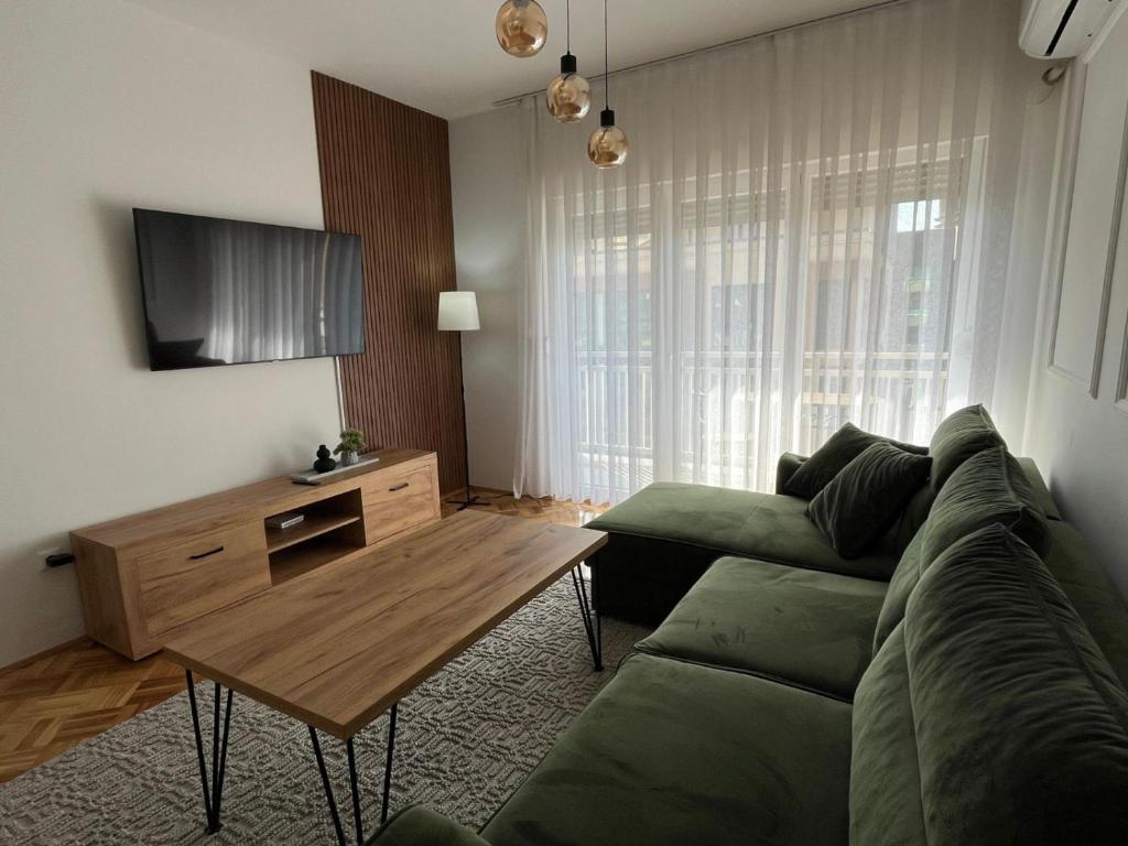 ŽiviniceZARA Apartman Živinice的客厅配有绿色沙发和木桌