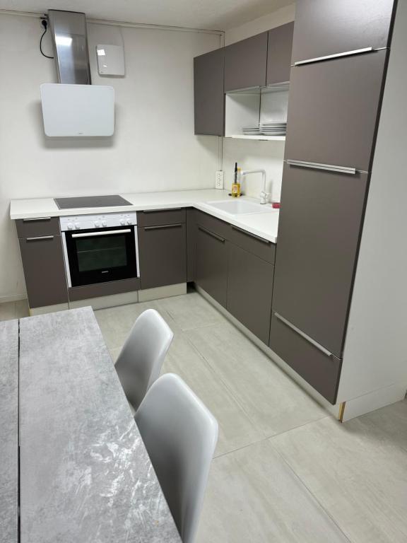 奥尔堡Italian Rooms 10的厨房配有灰色橱柜和桌椅