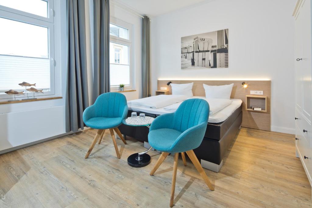 诺德奈Haus Menno Janssen - Doppelzimmer的一间卧室配有一张床和两张蓝色椅子