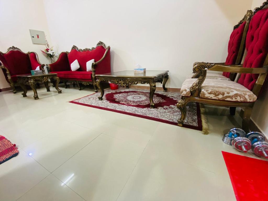 乌姆盖万Serene Nest的客厅配有红色椅子和桌子
