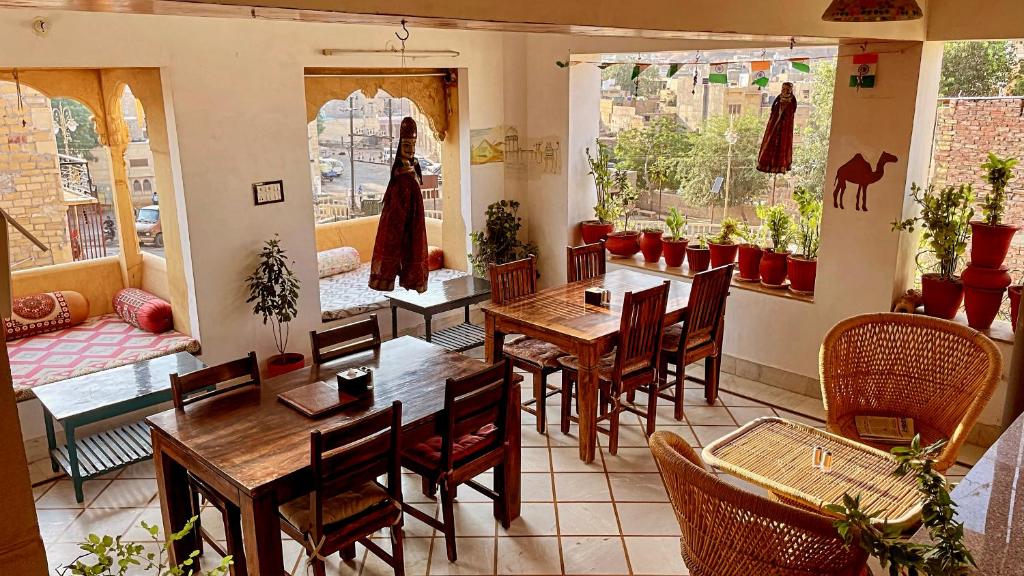 斋沙默尔The Wanderlust Guest House & Safari的一间在房间内配有桌椅的餐厅