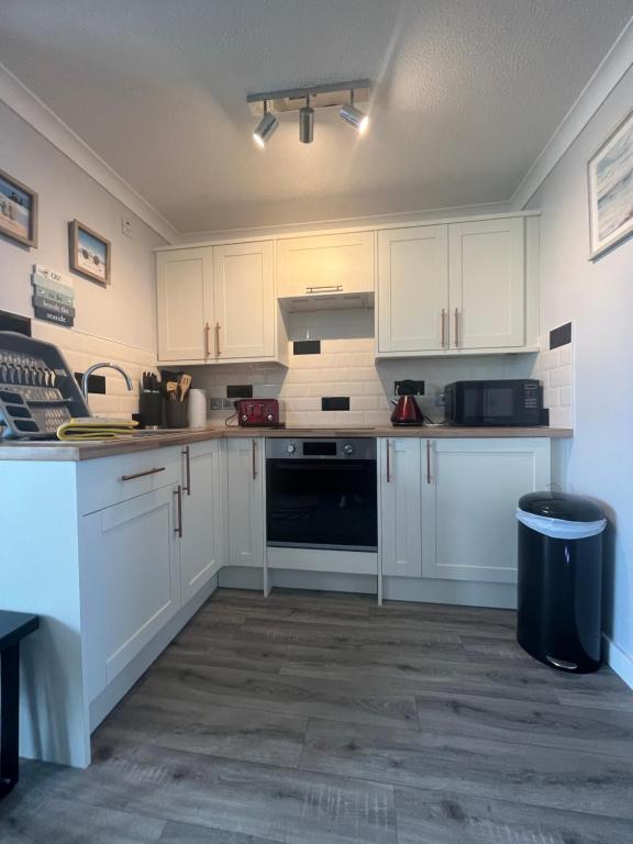 大雅茅斯246, Belle Aire, Hemsby - Beautifully presented two bed chalet, sleeps 5, pet friendly, close to beach!的厨房配有白色橱柜和黑色用具