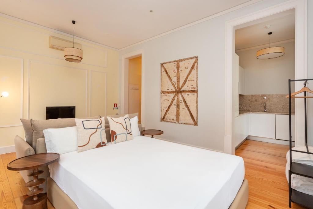里斯本卡萨斯·拜萨 - 朱丽思和马德琳酒店的卧室配有一张白色的大床和一张桌子
