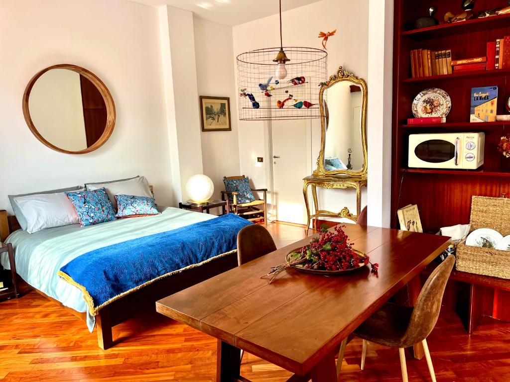 米兰Luxury Loft的一间卧室配有一张床铺和一张桌子,还有一间用餐室
