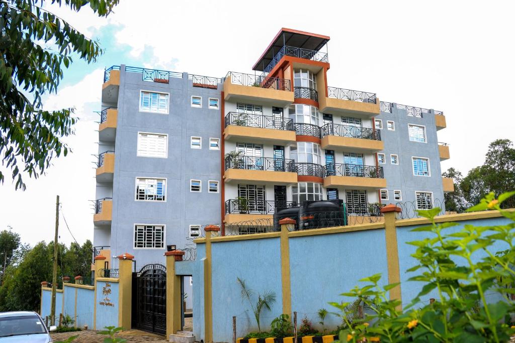 MeruMeru Heights Luxury Apartments的一座高大的灰色建筑,在栅栏顶部设有阳台