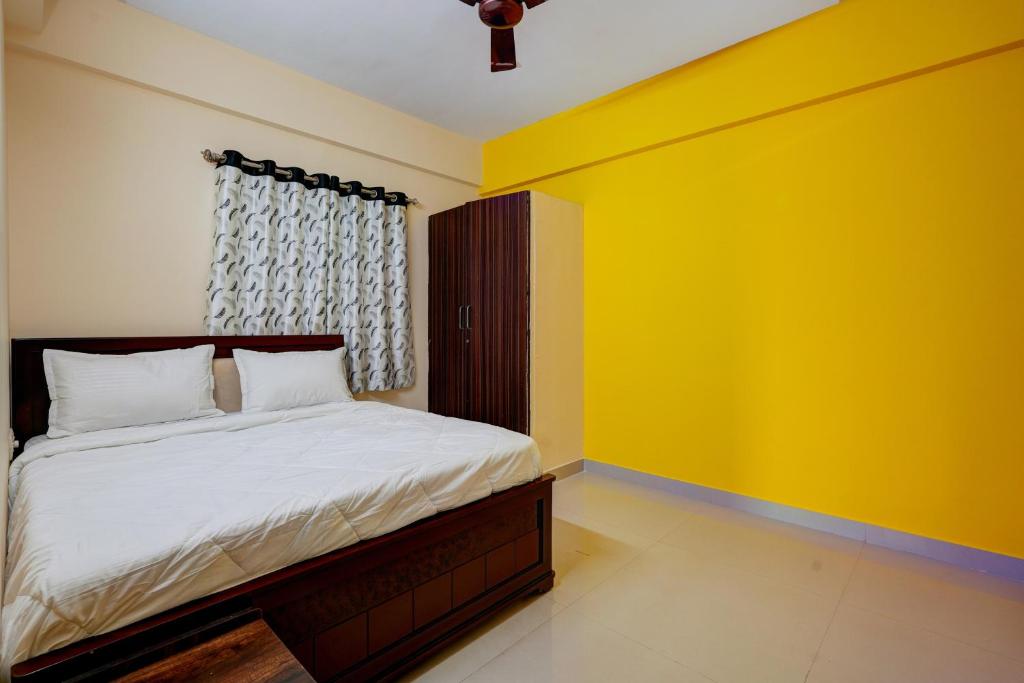 班加罗尔OYO Hotel SD的一间卧室配有一张黄色墙壁的床