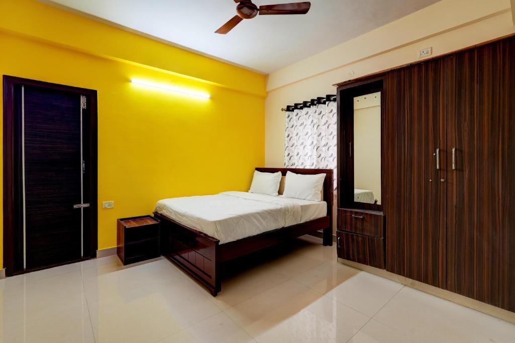 班加罗尔OYO Hotel SD的一间卧室设有一张床和黄色的墙壁