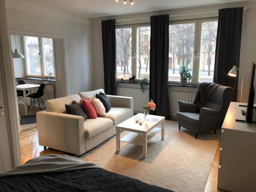 斯德哥尔摩Lovely Ostermalm apartment的客厅配有沙发、两把椅子和一张桌子