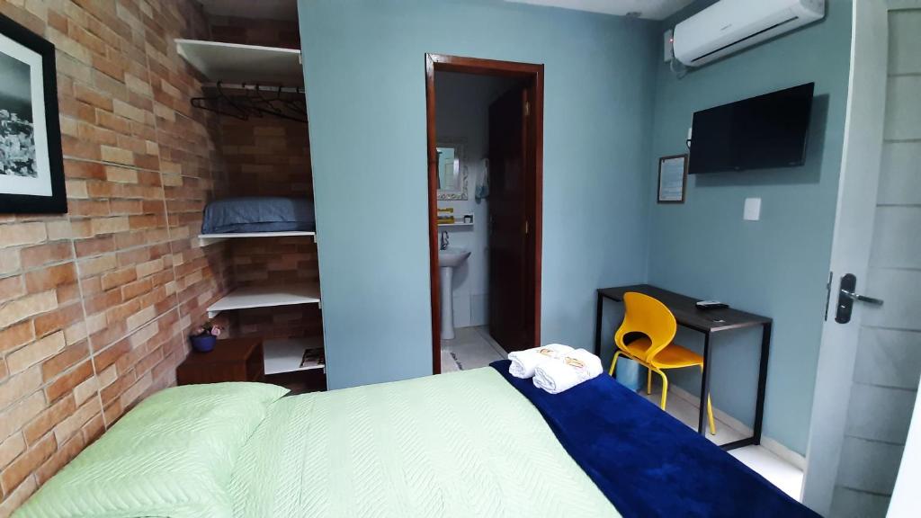 布卢梅瑙Pousada Casa da Maga - Centro的一间卧室设有一张床和砖墙