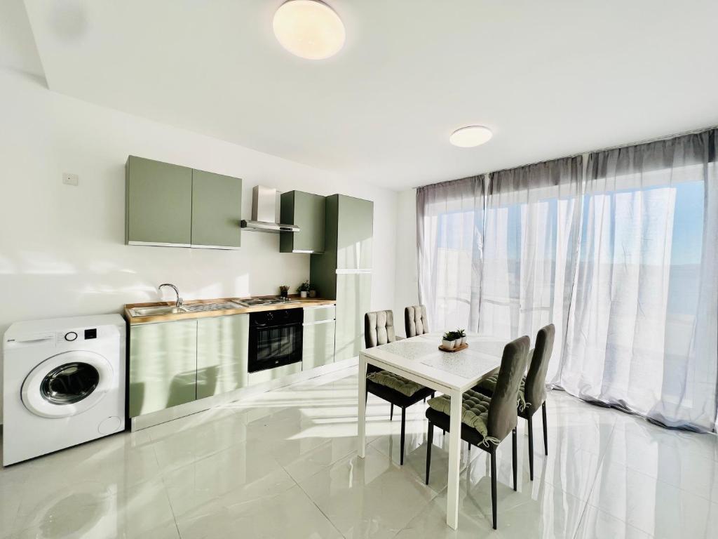 姆西达SUNSHINE SUITS - BRAND NEW APARTMENTS的厨房配有桌椅和洗衣机。