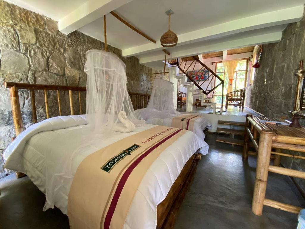库埃察兰德尔普罗格雷索Cabañas Tosepan Kali的一间卧室设有两张床和石墙