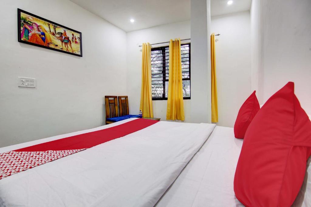 新德里Super OYO Flagship Blossom Inn Burari的卧室配有带红色枕头的大型白色床