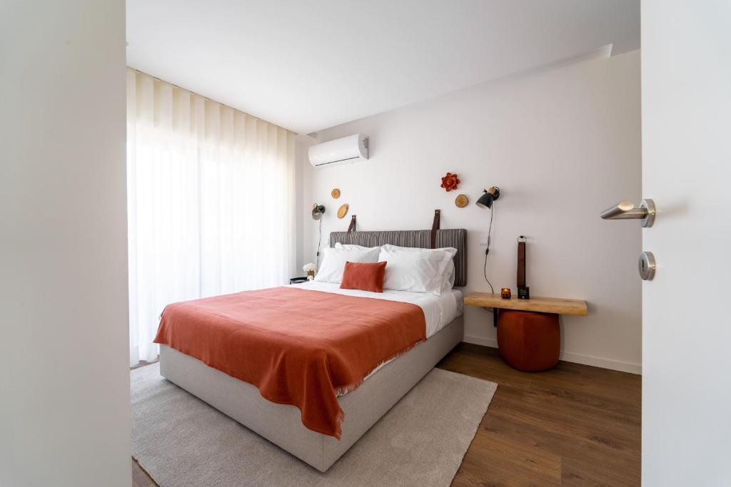 布拉加João da Ponte - T1 Altice Forum Braga by House and People的一间卧室配有一张带橙色毯子的床