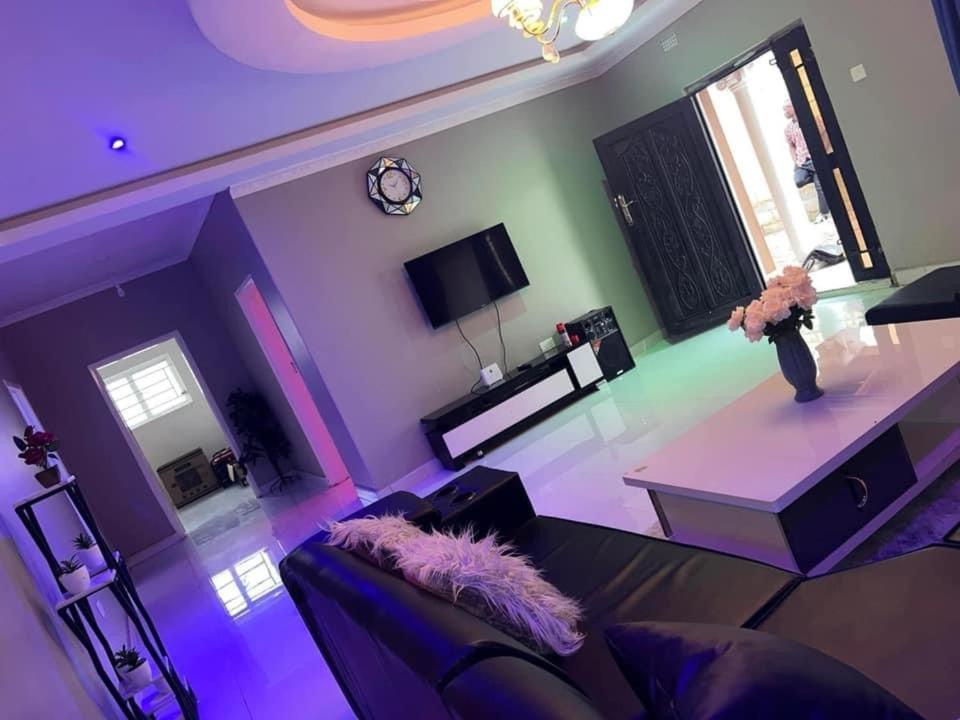 卢萨卡Joydora apartments 3的紫色的客厅配有沙发和桌子