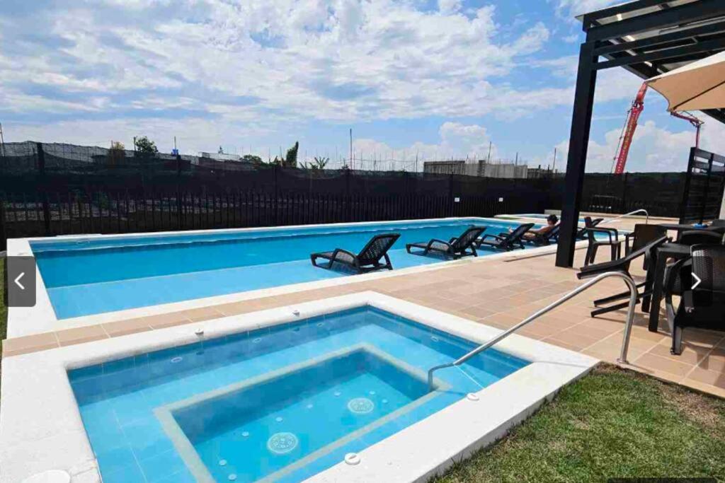 拉特瓦伊达Casa Familiar Excelente ubicación con Piscina的一个带椅子和桌子的大型游泳池