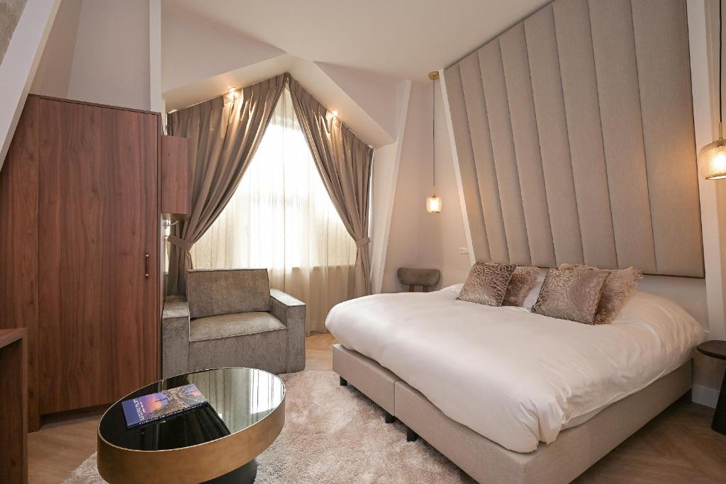 海牙Novallure Downtown - Short Stay Apartments的配有一张床和一把椅子的酒店客房