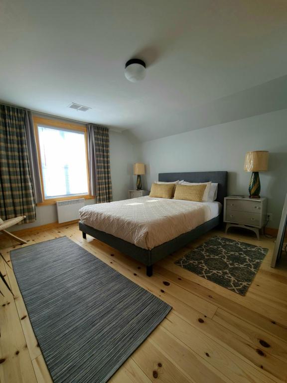 罗登La Petite Auberge Sur Queen的一间卧室设有床、窗户和地毯。