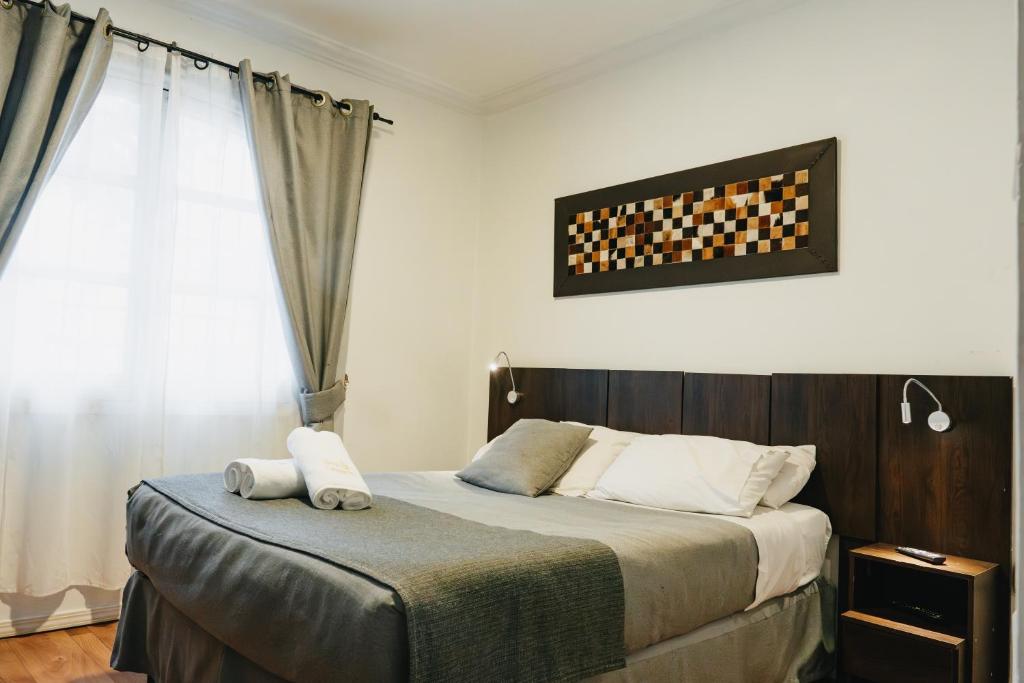 康塞普西翁Apart hotel de Hostal Concepción的一间卧室设有一张床和一个窗口