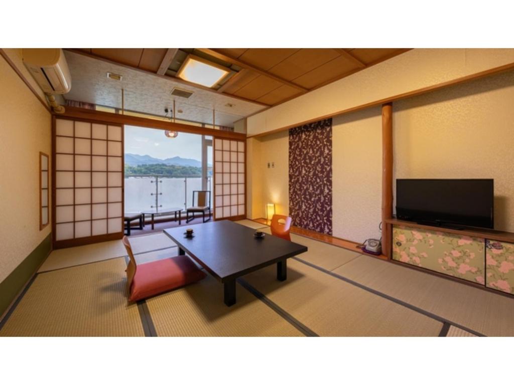 日田市Mikuma Hotel - Vacation STAY 63475v的一间房间,内设桌子和电视