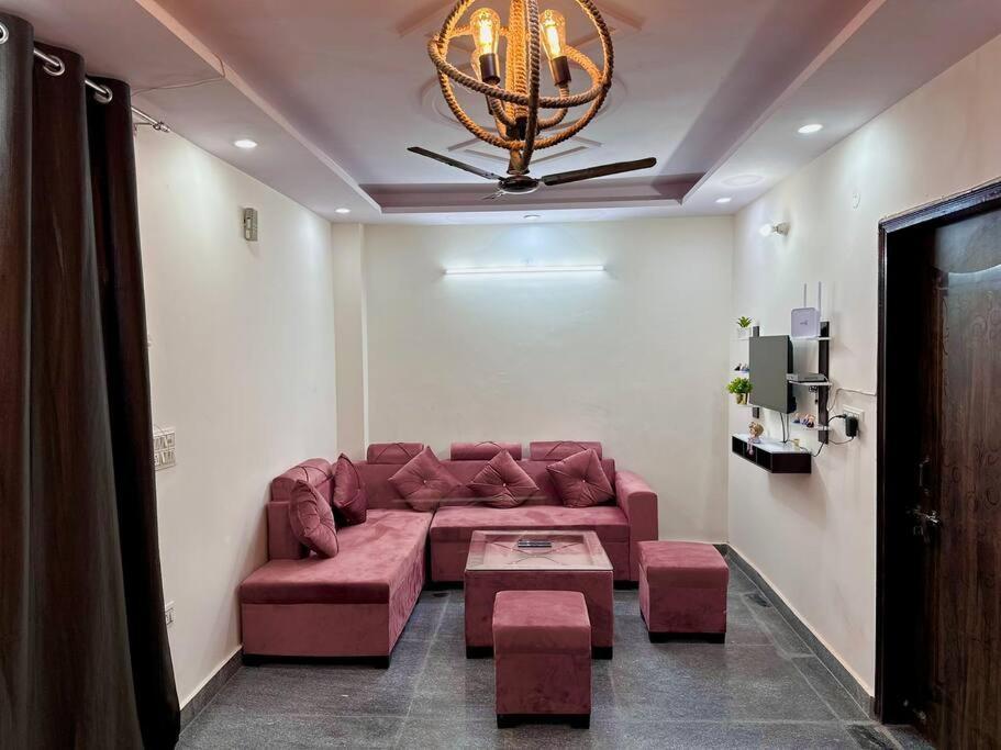 新德里Modern 2bhk near Delhi Airports by Nirvana villa Apartments的客厅配有红色的沙发和桌子