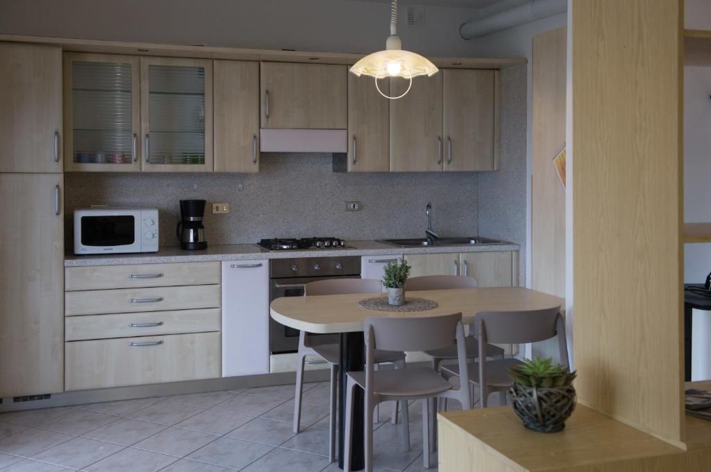 滕诺Appartamento Girasole con balcone e vista的厨房配有桌椅和微波炉。