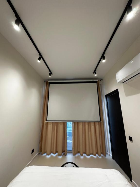 阿拉木图Дом с потрясающим видом的卧室设有大窗户和大屏幕白色屏幕