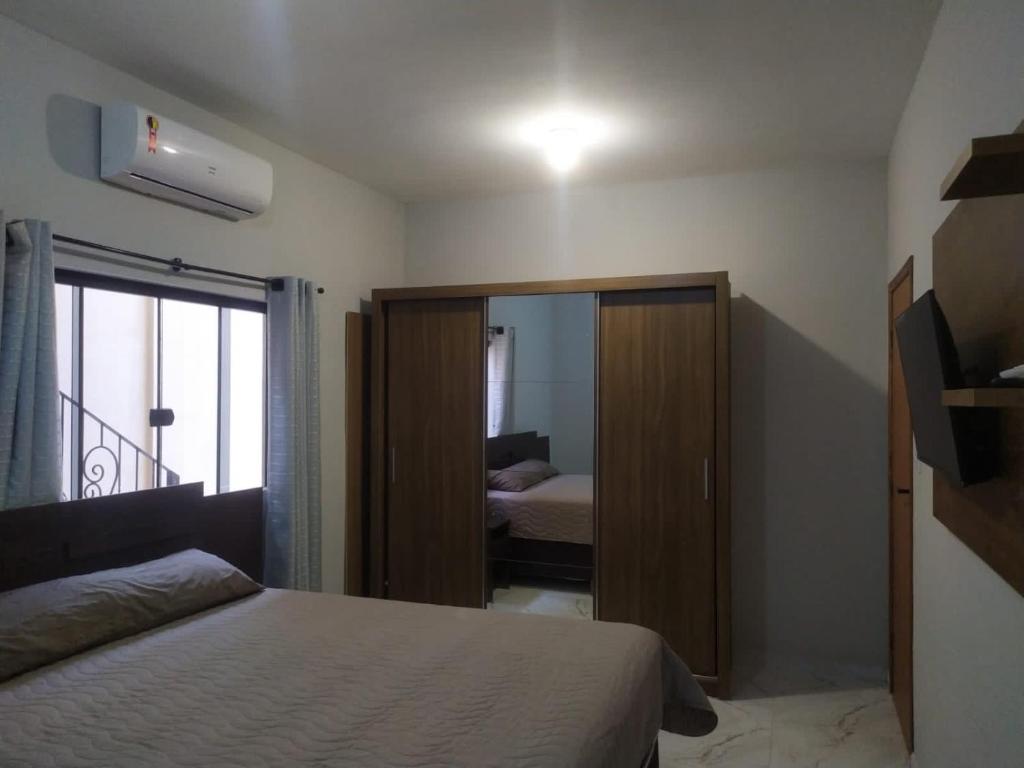 圣若昂-德雷Novo Horizontes的一间卧室配有一张床和一个带镜子的衣柜