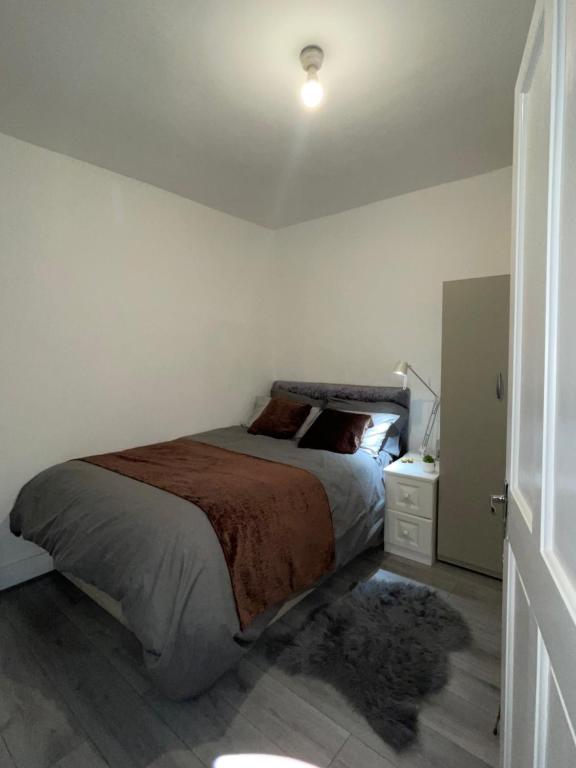 伦敦COZY ROOMS 25 min LIVERPOOL STREET的一间卧室配有一张大床和一个床头柜